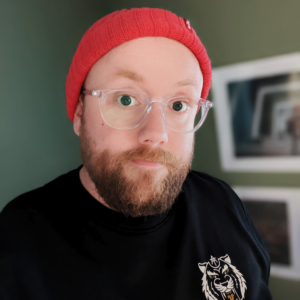 Danny Payne. White male in clear glasses, red hat and a short beard